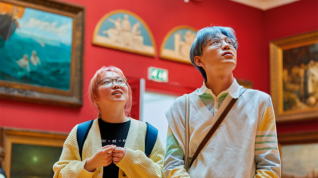 Young South East Asian couple with colourful hair basking in the art work at Leeds Gallery